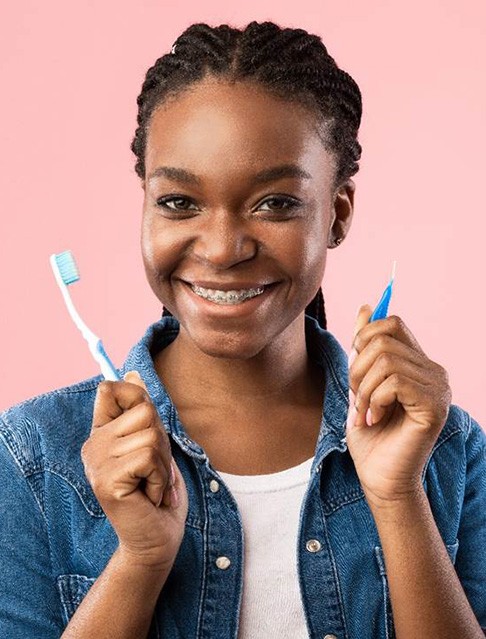 Woman with traditional braces holding toothbrush