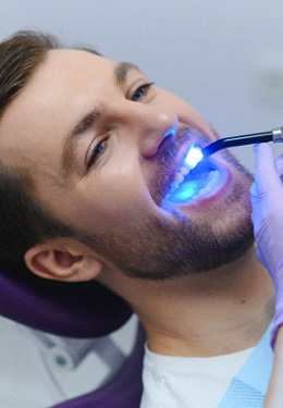 Man having dental filling hardened with UV light