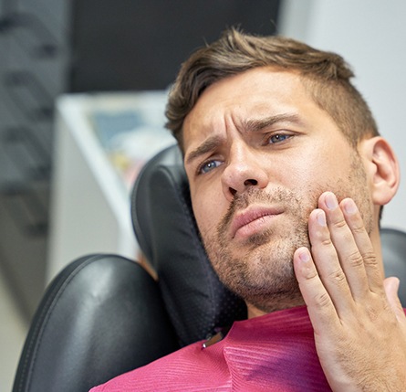 Patient with toothache sitting in treatment chair