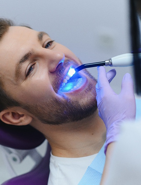 A young, bearded man receiving a tooth-colored filling