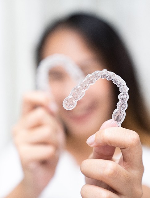 Woman holding two clear aligners