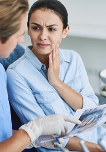 Patient in Parker holding cheek due to a cavity