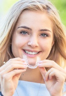 Patient in Parker holding clear aligners