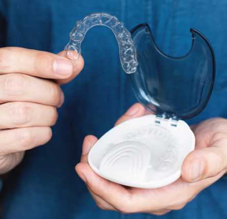 Teen holding clear aligner and case