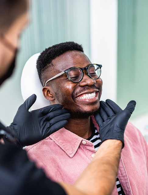 Dentist looking at smiling's patients teeth