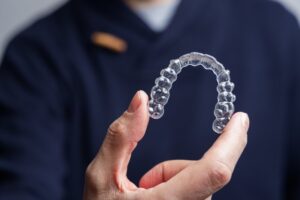 Person holding up a clear aligner